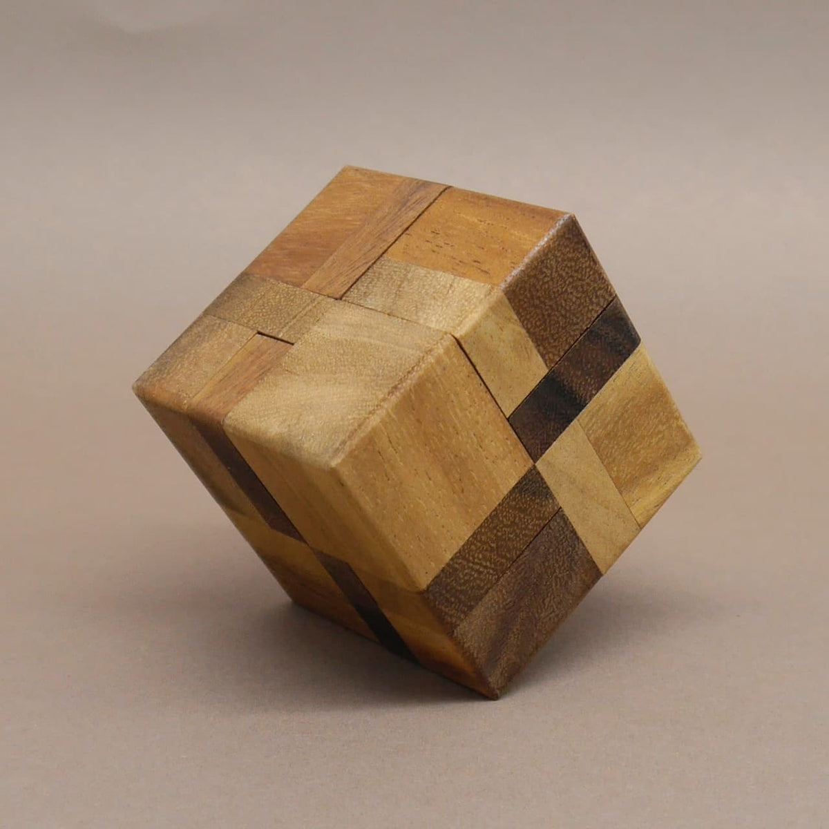 Holzpuzzle: sauber montierter Würfel mit abwechselnden Holzfarben bildet ein Blockmuster und steht leicht gekippt.