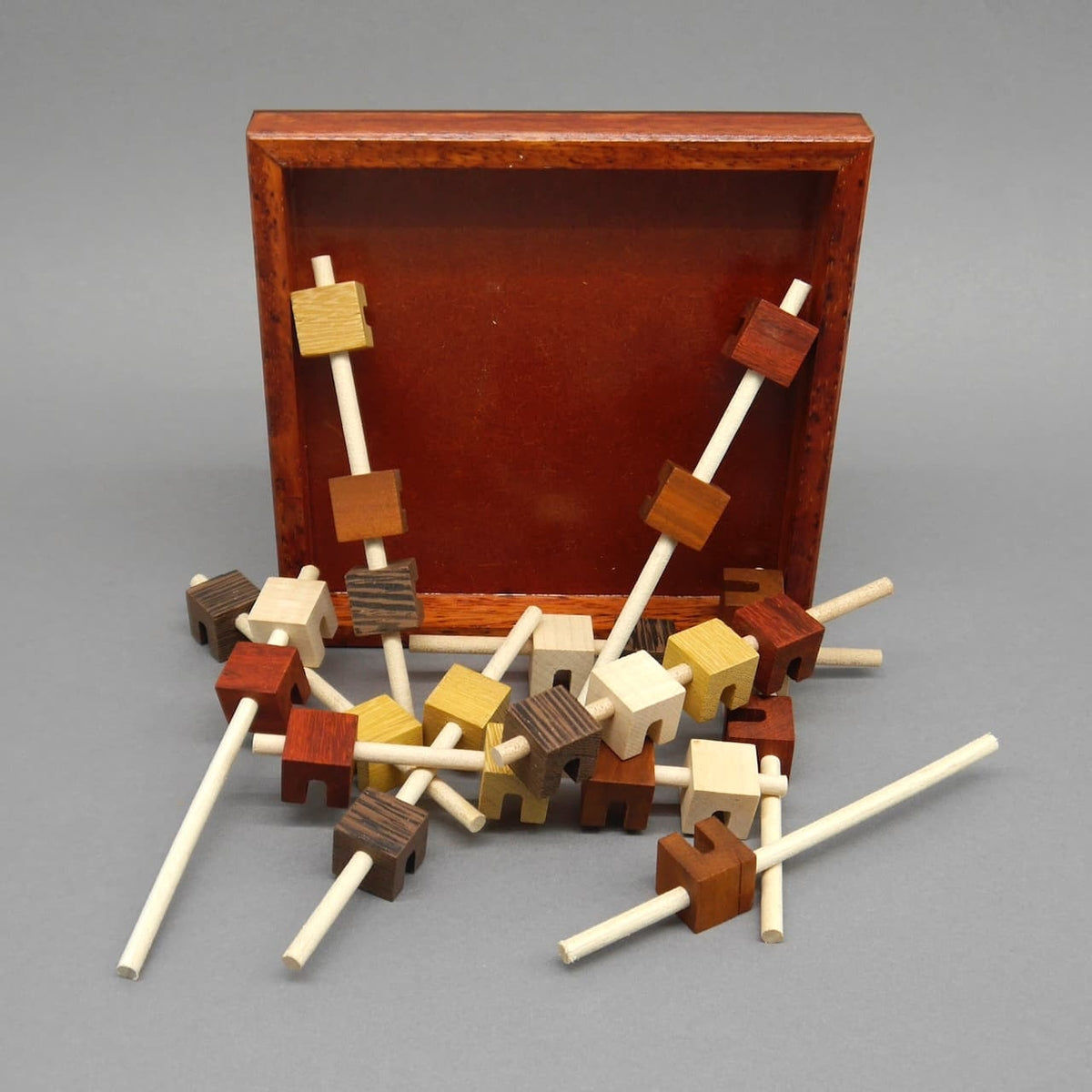 Das ‚Brochettes‘-Holzpuzzle in Einzelteilen, die zu einem 3D-Objekt kombiniert werden können. Ein Geduldsspiel zur Förderung von Gehirntraining und logischem Denken.