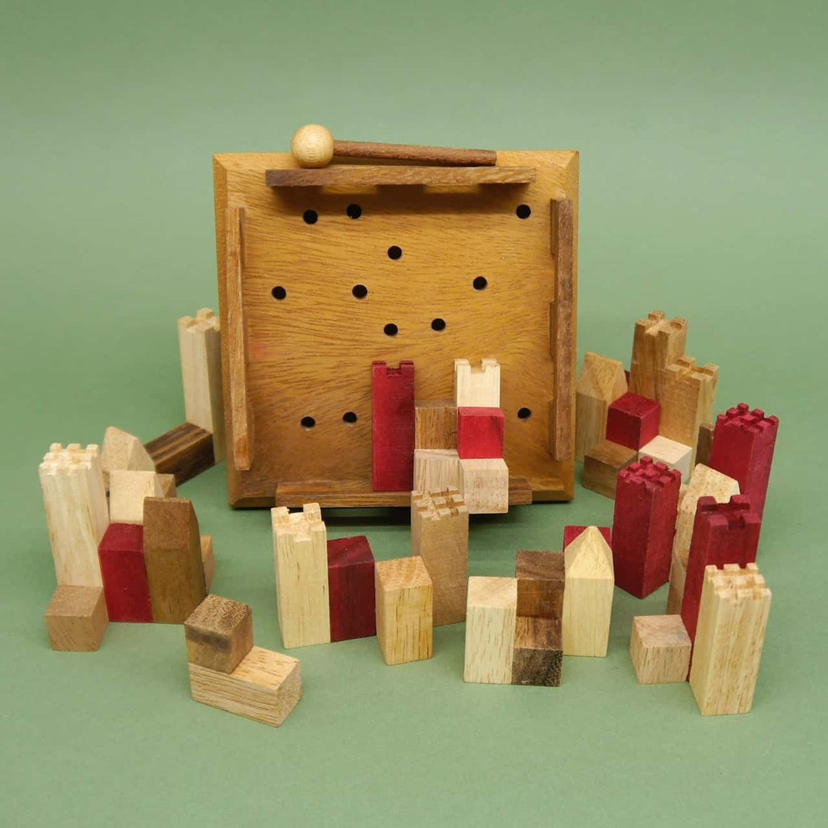 Zerlegte Holztürme und Blöcke liegen als Braingame rund um ein gelochtes Spielfeld; das Burgpuzzle wartet darauf, wieder zusammengesetzt zu werden.
