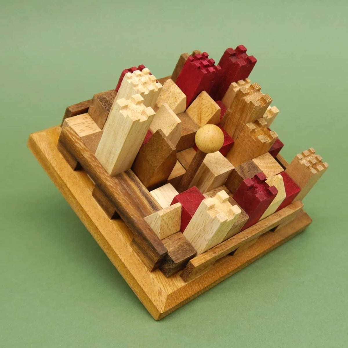 Schrägansicht eines vollständig gesteckten Burg-Knobelspiels aus unterschiedlich hohen Holzklötzen in Rot und Natur, eng gefasst in einem quadratischen Rahmen.