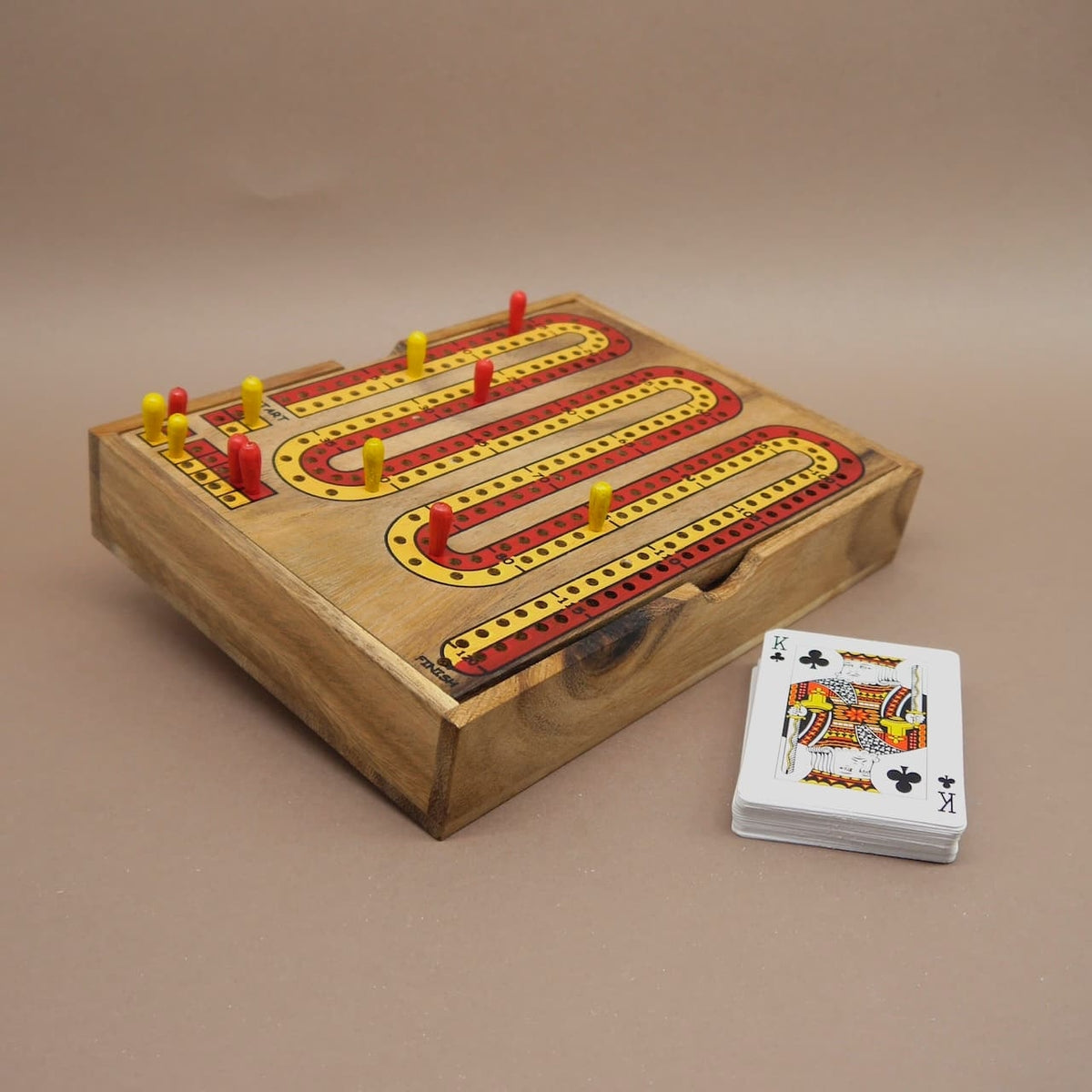 Cribbage-Brett aus Holz mit gesteckten Spielfiguren und einem Kartenstapel – ein klassisches Gesellschaftsspiel für gesellige Runden.