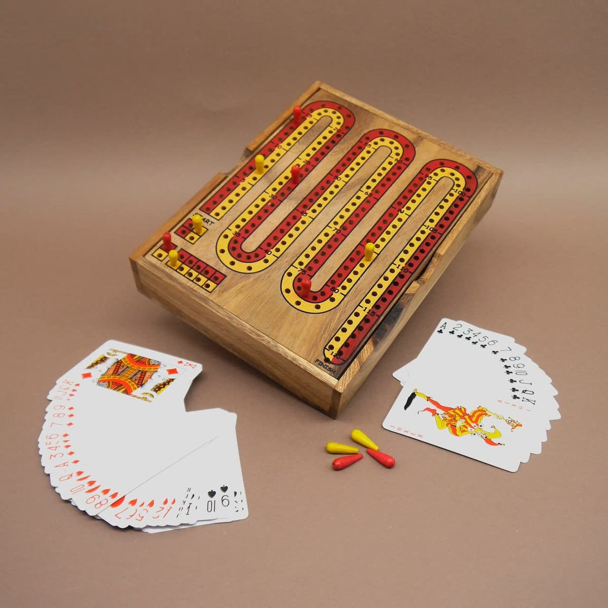 Cribbage-Spiel mit aufgefächerten Kartenspielen, farbigen Spielstiften und robustem Holzbrett – ein unterhaltsames Denkspiel für Kinder und Erwachsene.