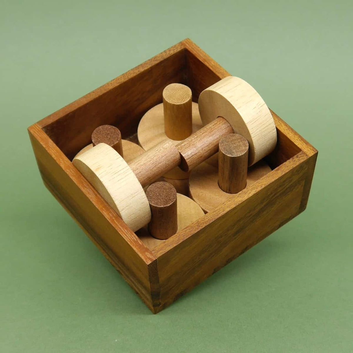 Holzstücke sind dicht gepackt in einer quadratischen Knobelbox, aufgenommen aus der Vogelperspektive.