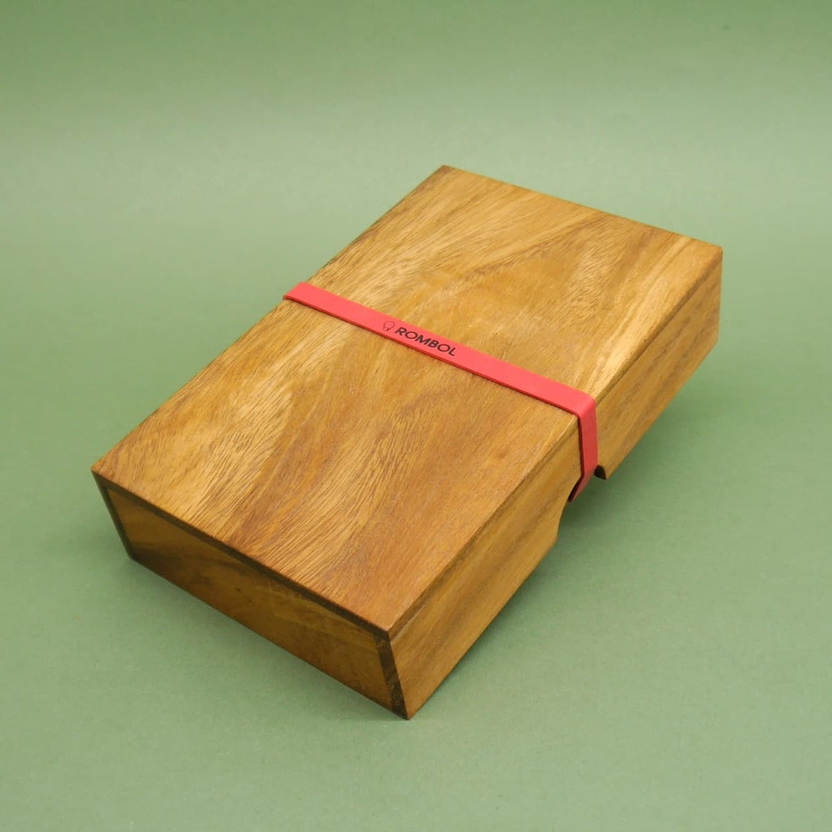 Geschlossene Holzbox mit rotem Gummiband, enthält ein Domino-Doppel-9 – ein durchdachtes Taktikspiel im kompakten Format.