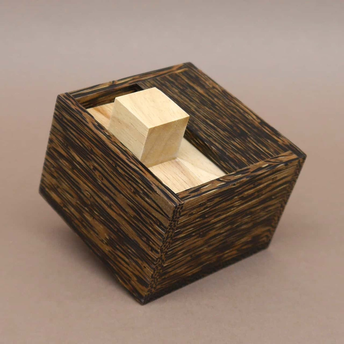 Dunkler Holzwürfel mit eingeklemmtem Holzklotz – ein anspruchsvolles denkspiel zum Packproblem.