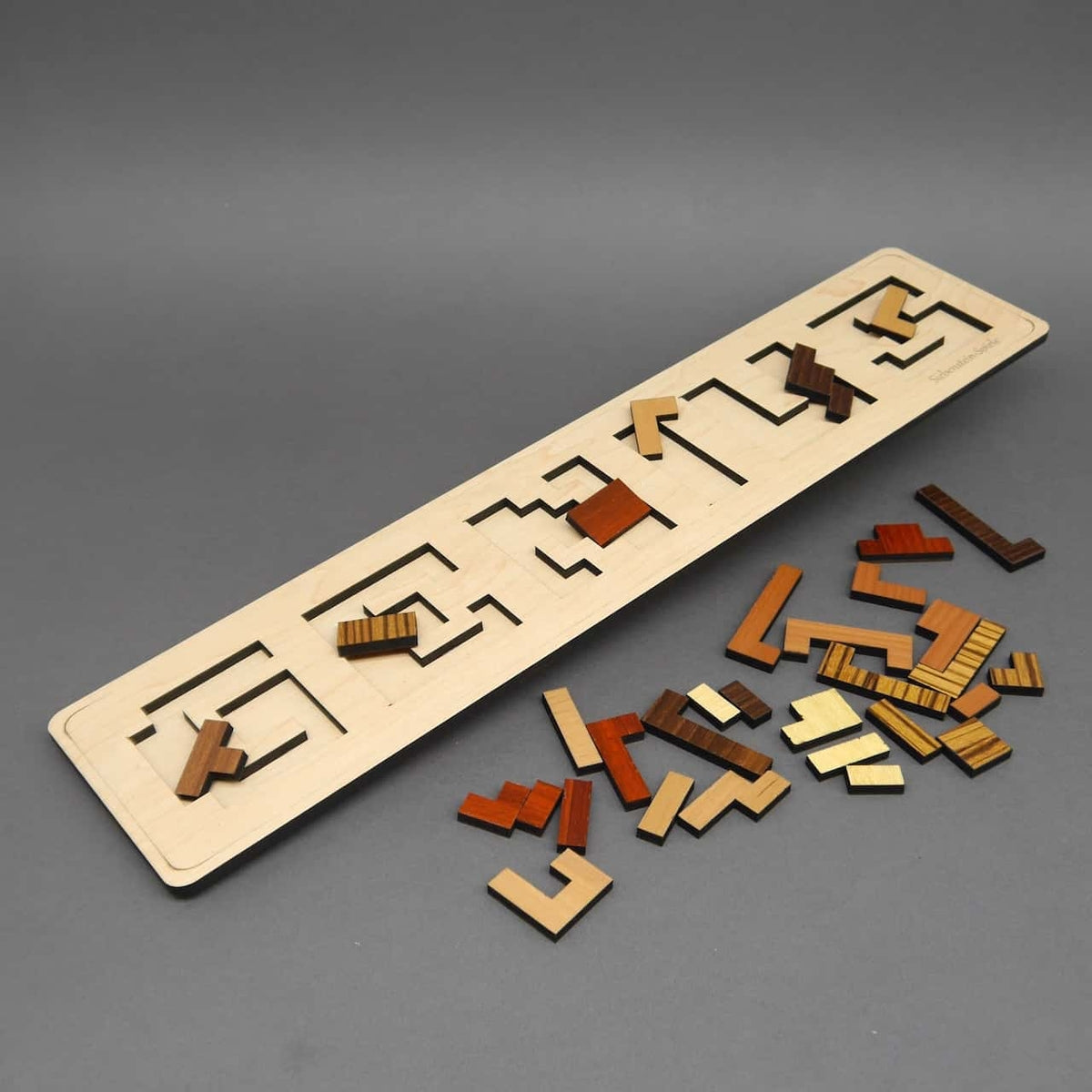 Ein hölzernes Logik- und Knobelspiel mit herausnehmbaren Teilen, die zu einer geometrischen Figur zusammengesetzt werden.