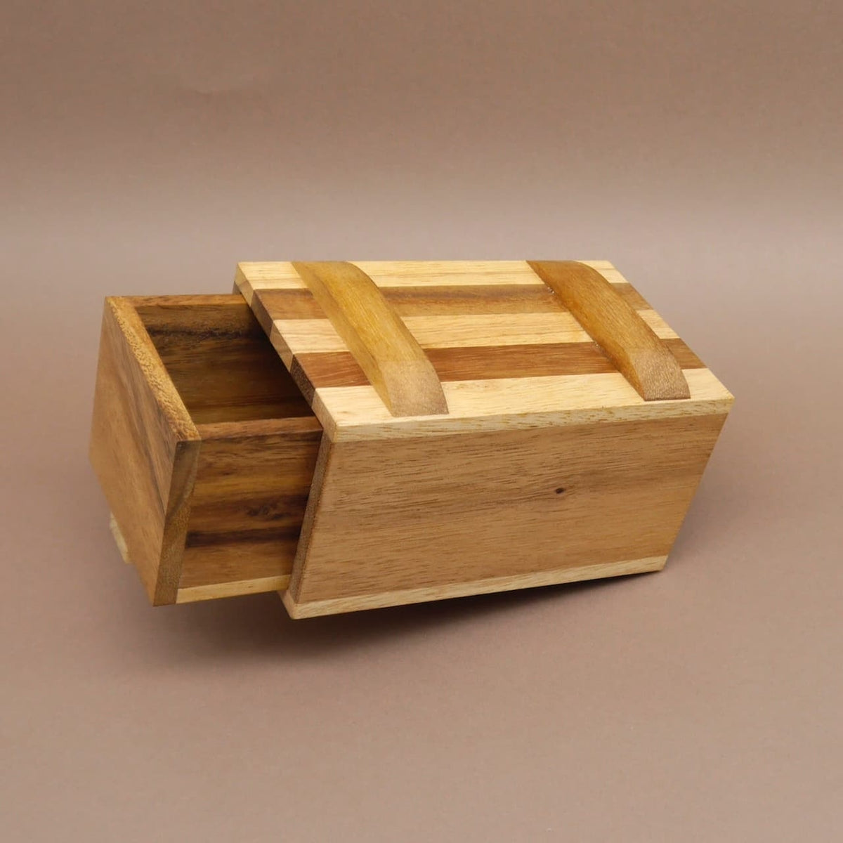 Offene Holz‑Geschenkbox, das Schubfach des Geduldspiel ist herausgezogen und gibt das Geheimfach frei.
