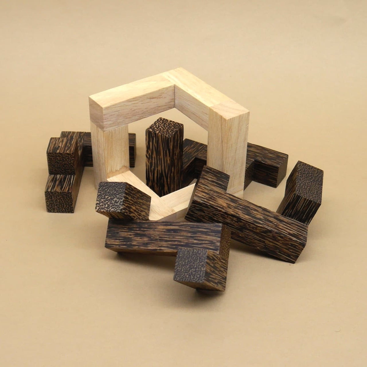 Dunkle Holzklötze und ein heller sechseckiger Rahmen bilden ein verstreutes Puzzle als anspruchsvolles Gehirntraining.