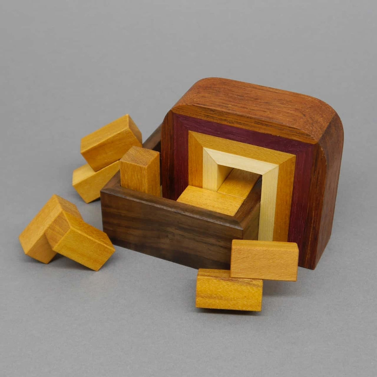 Komplexes 3D-Knobelspiel aus Holz, bei dem verschiedene Bausteine passgenau in einer Form angeordnet werden müssen.