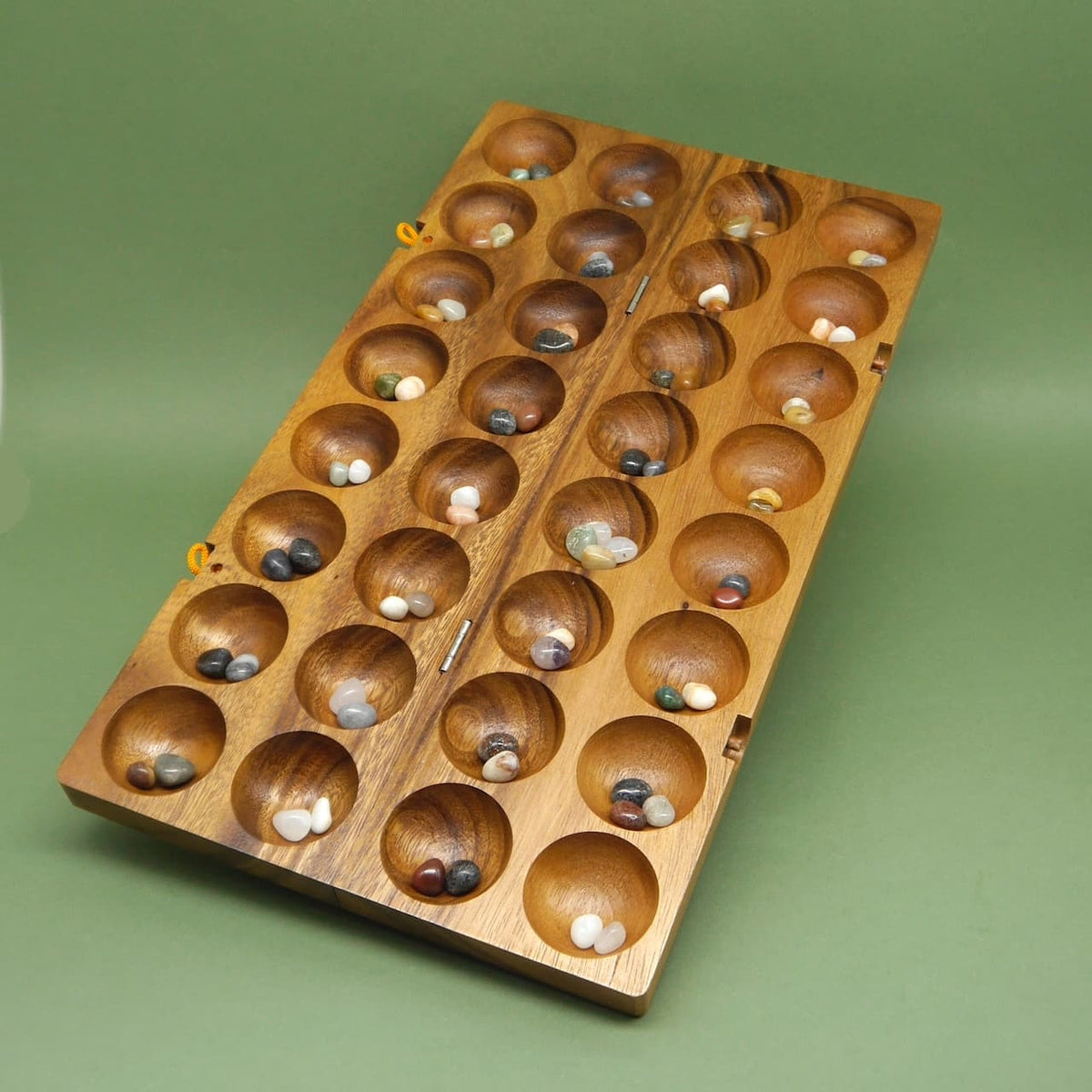 Afrikanisches Holzspiel Hus Bao, Kalaha Strategiespiel aus Holz mit bunten Spielsteinen.