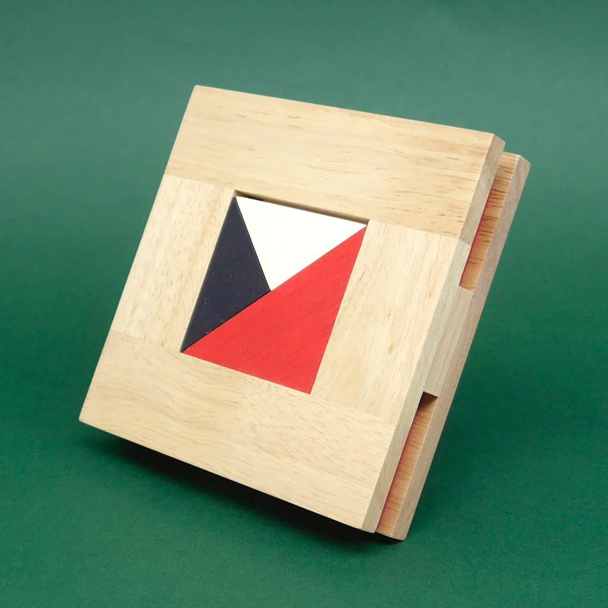 Quadratisches Holzbrett mit rot-schwarz-weißem Dreiecksmuster, komplett eingesetzt – kompaktes Denkspiel für zwischendurch.