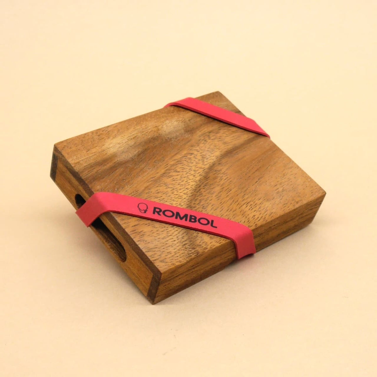 Quadratisches Holzpuzzle in eleganter Box mit rotem ROMBOL-Band – ideales Knobelspiel für unterwegs.