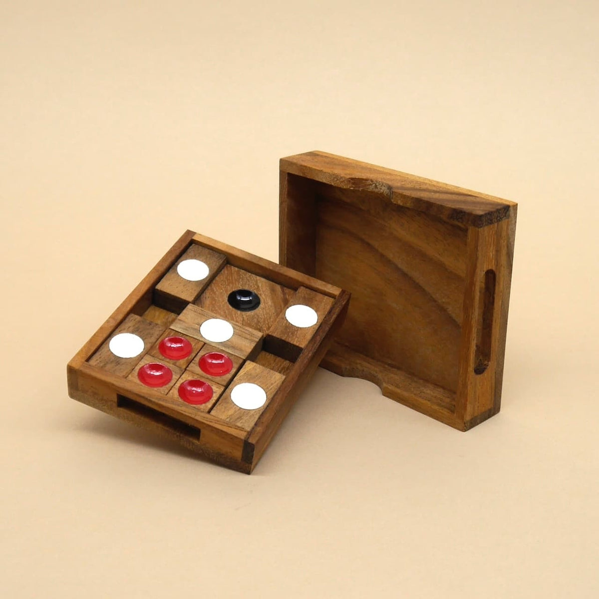 Geöffnetes Holzpuzzle mit roten, weißen und schwarzen Spielsteinen – ein raffiniertes Logikspiel für Geduldige.