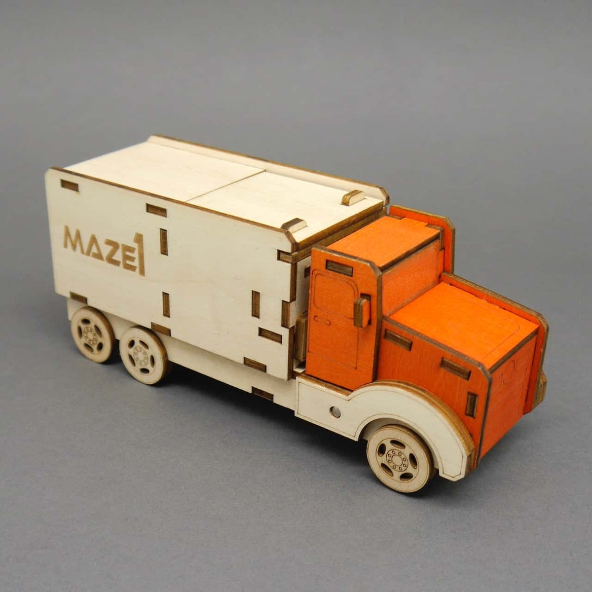 Seitliche Detailansicht des Maze1 Holz-Trucks als Trickbox-Denkspiel mit orangefarbener Kabine