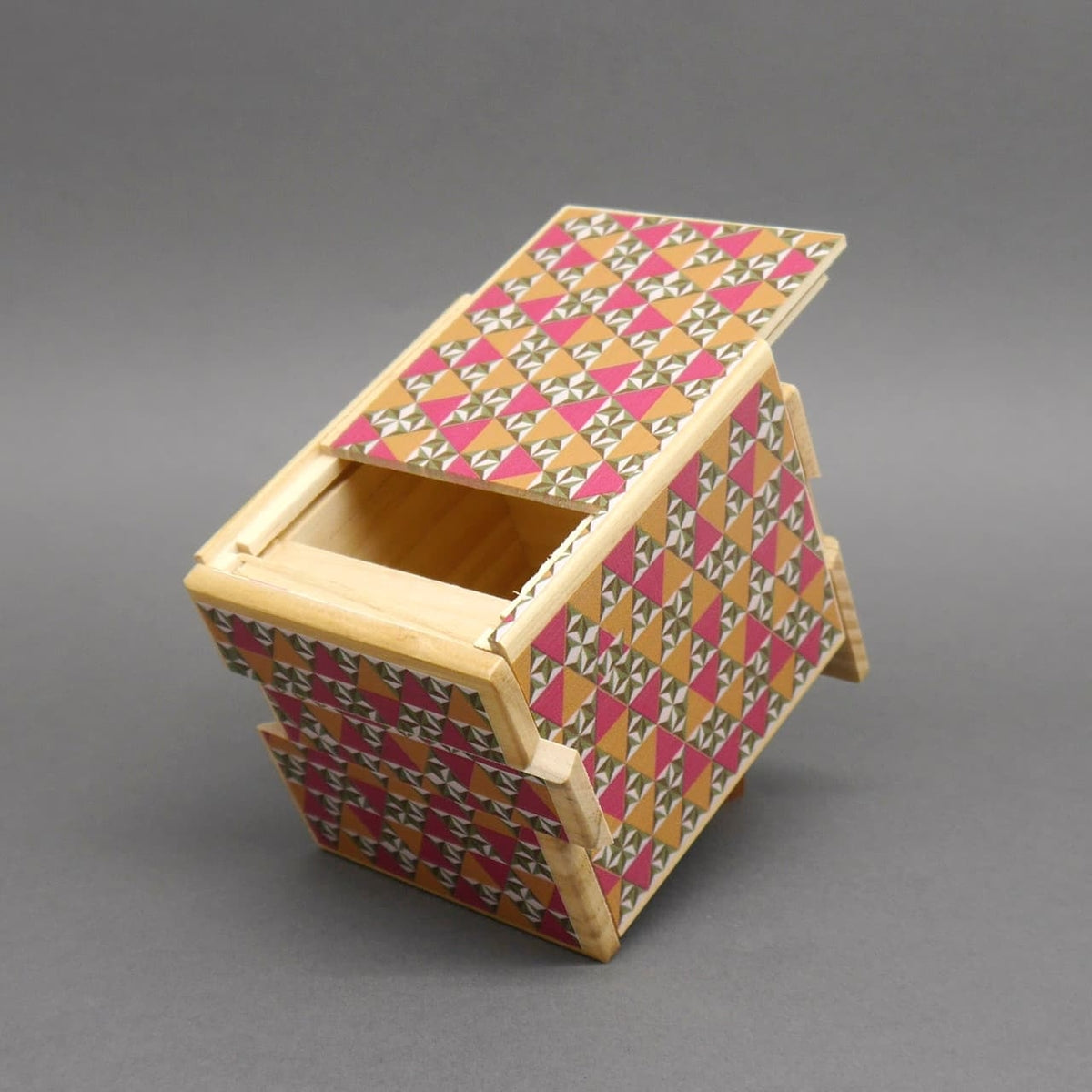 Teilgeöffnete Schatzkiste aus Holz mit aufwendigem geometrischen Design, zeigt die innere Kammer eines logischen Puzzles.