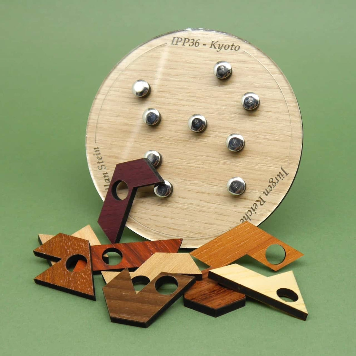 Verschiedenfarbige, geometrische Holzteile, die ein kniffliges Logikpuzzle bilden und durch unterschiedliche Anordnung zu immer neuen Mustern führen