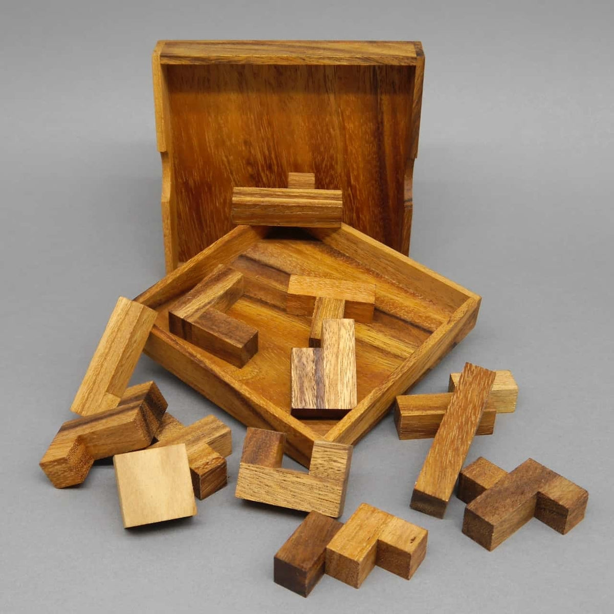 Einzelne Holzpuzzle-Teile des „Spiel des Lebens“ verstreut vor der Holzbox – ein anspruchsvolles Holzpuzzle.