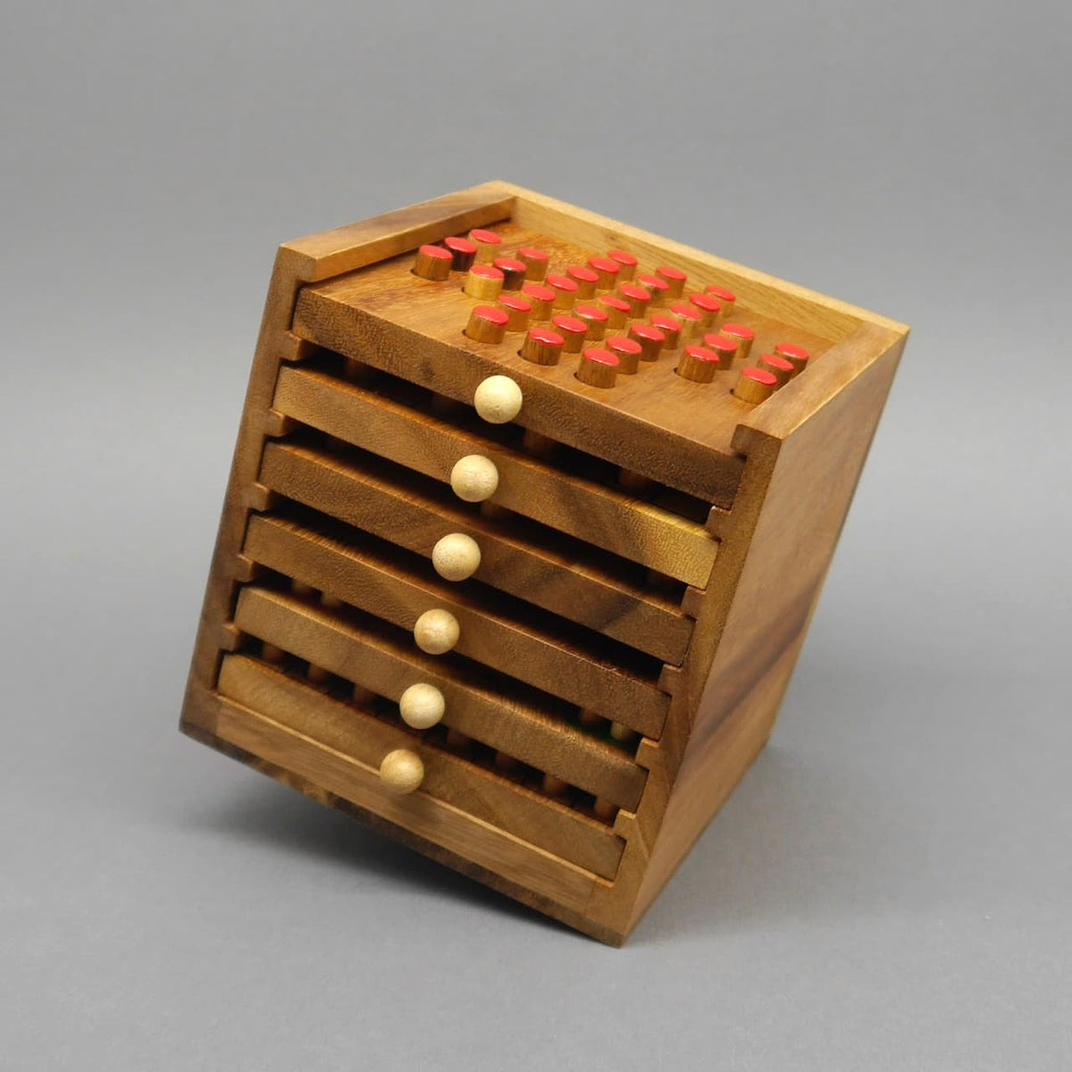 Geschlossene Spielesammlung aus Holz mit stapelweise Schubladen – kompakte Familienspiele für unterwegs.