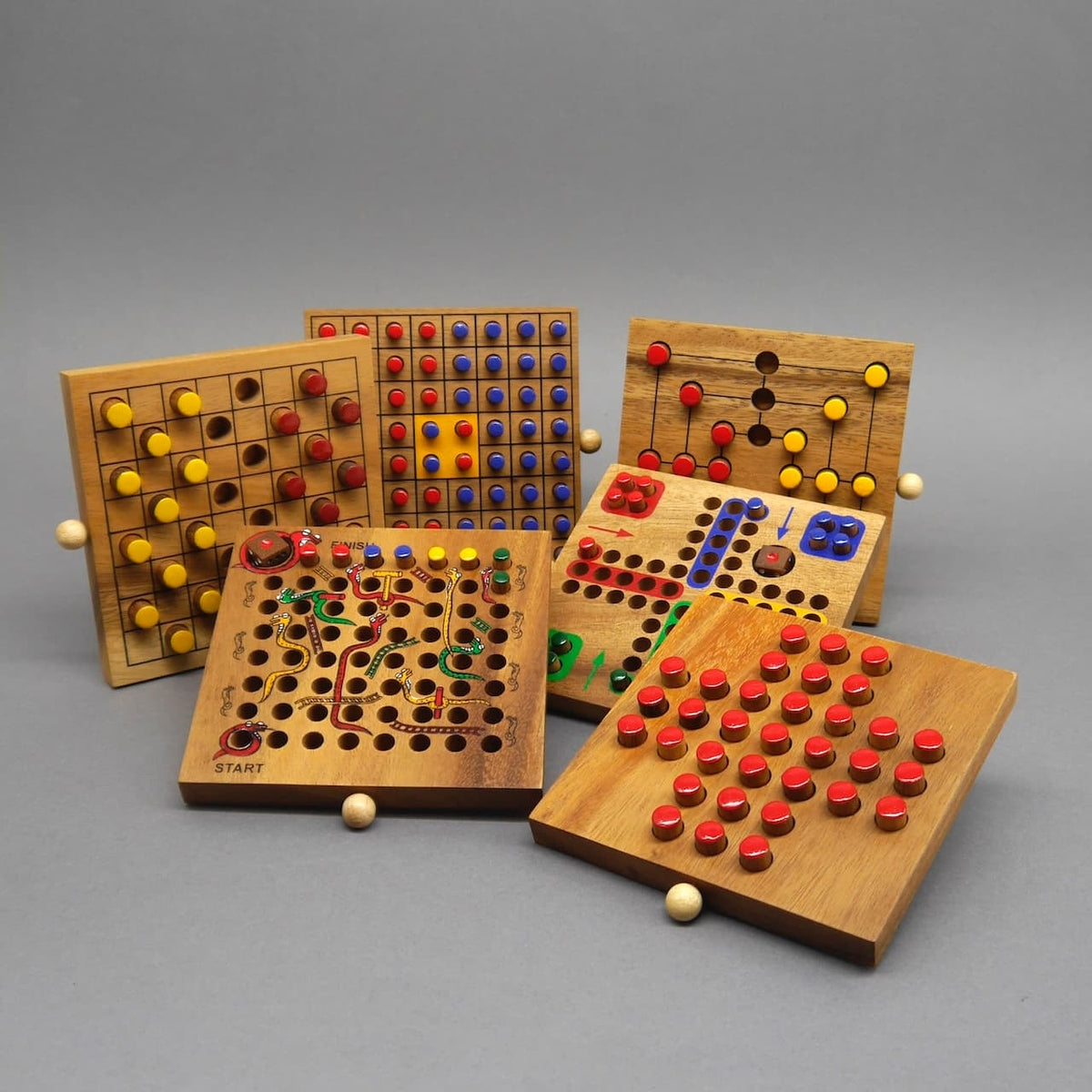Bunte Steckspiele bilden einen Halbkreis vor der leeren Holzbox – perfekte Inspiration für den nächsten Spieleabend.