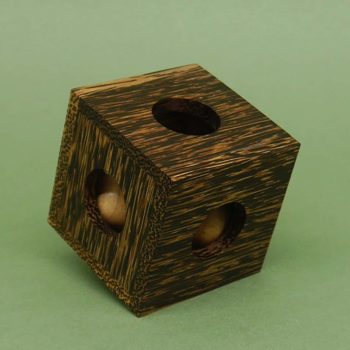 Geschlossener Würfel aus gemasertem Holz; einzelne Kugeln sind in den Bohrungen zu sehen – ein kniffliges Braingame in edler Optik.