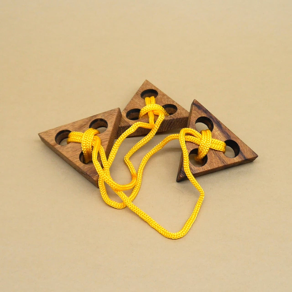 Dreieckiges Holzpuzzle mit gelber Schnur, ein anspruchsvolles Denkspiel aus Holz.