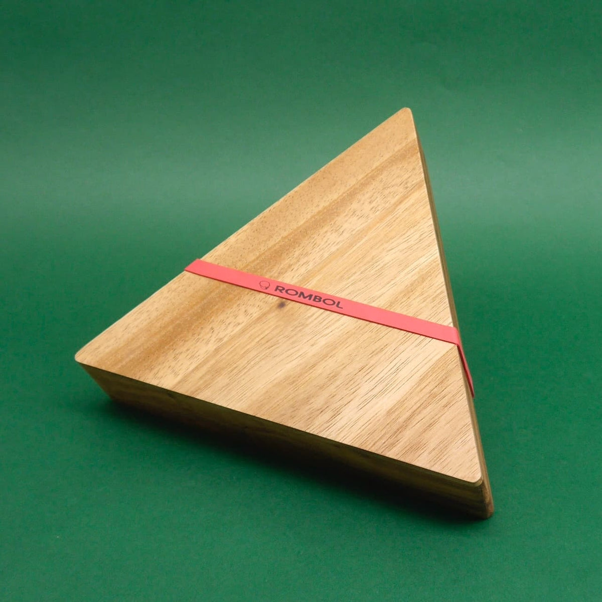 Dreieckige Holzbox mit dem Logo "Rombol" auf grünem Hintergrund – das Holzspiel ist vollständig geschlossen.