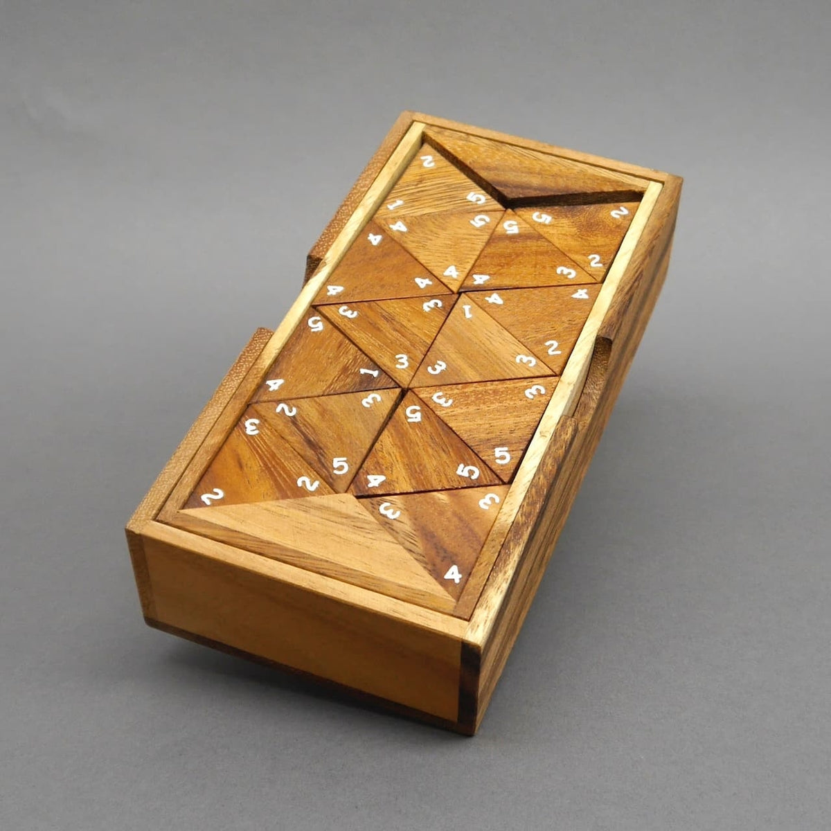 Fertig gelegtes Tridomino-Zahlenspiel aus Holz mit weißen Ziffern auf dreieckigen Spielsteinen.