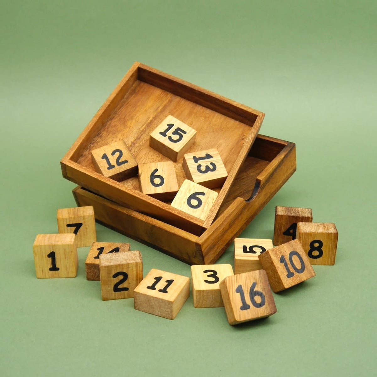 Offene Holzbox mit verstreuten nummerierten Würfeln – ein anspruchsvolles Woodenpuzzle.