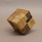 Holzpuzzle: sauber montierter Würfel mit abwechselnden Holzfarben bildet ein Blockmuster und steht leicht gekippt.