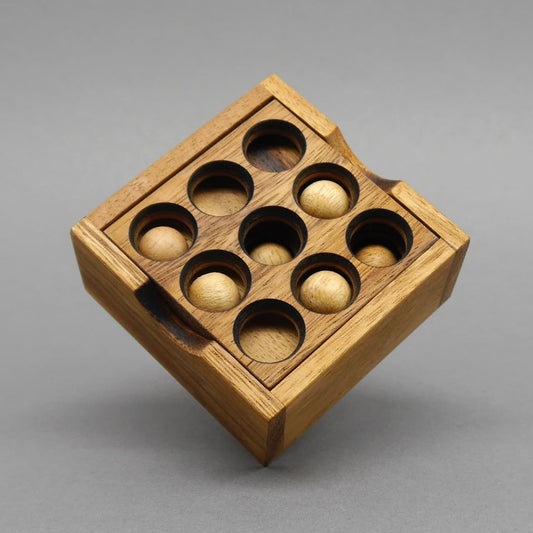 Fertig gestecktes 9‑Loch‑Puzzle: neun Holzkugeln sauber in den Aussparungen – kompaktes Denkspiel aus Samena-Holz.