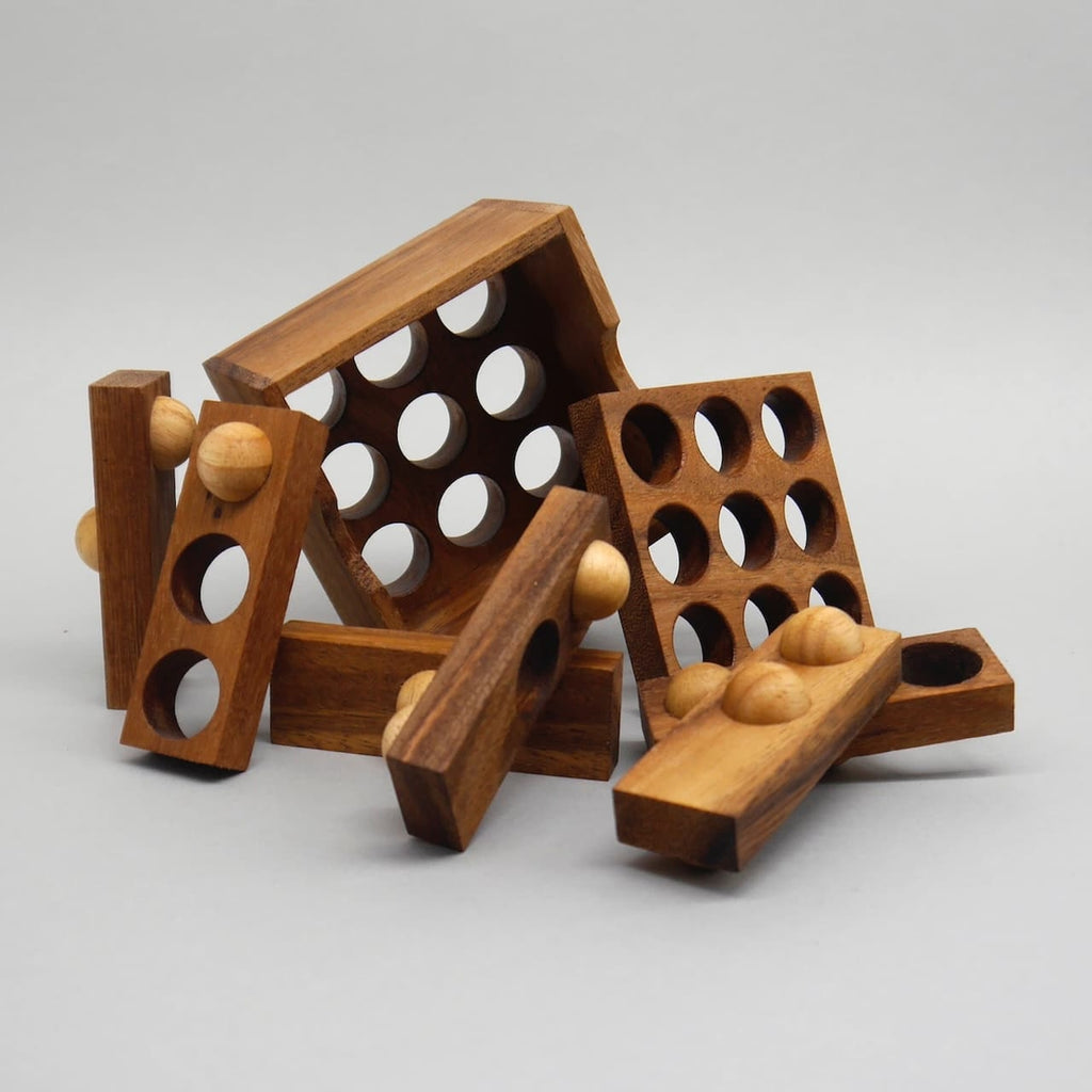 Mehrere gelochte Holzplatten und Kugel‑Leisten des 3‑D‑Puzzles liegen locker verstreut – ein typisches Geduldsspiel in Einzelteilen.