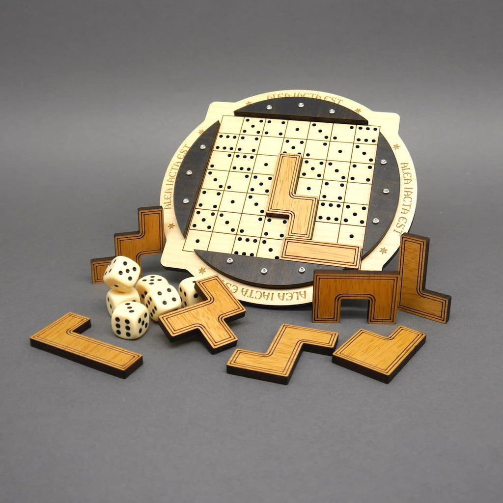 Knobelspiel mit eingesetzten und herausgenommenen Formteilen sowie mehreren Würfeln, vor rundem Spielbrett mit Lochraster und Gravur.