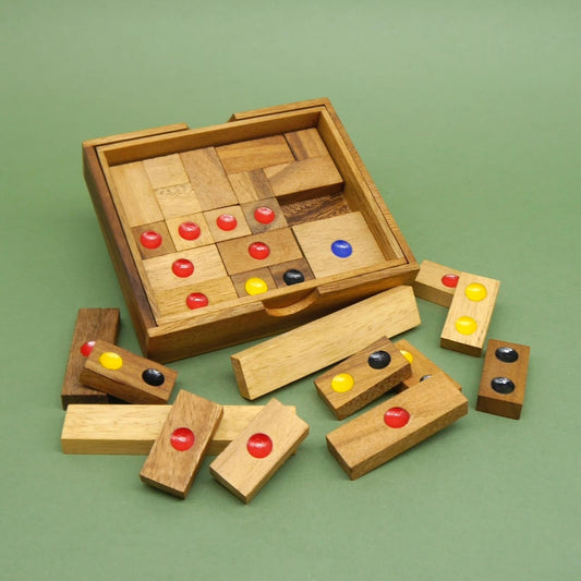 Holz‑Khun‑Pan Geduldsspiel: offene Box mit verschieden großen Schiebesteinen, die rote, gelbe, blaue und schwarze Punkte tragen; einige Teile liegen davor verstreut.