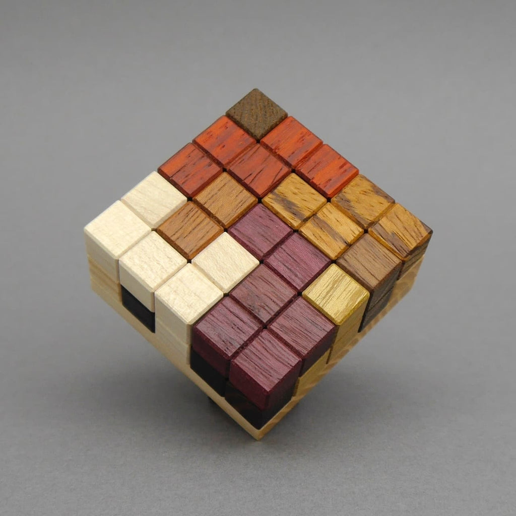 Komplett aufgebautes Holzpuzzle als bunter 3D-Würfel aus verschiedenfarbigen Holzklötzen.