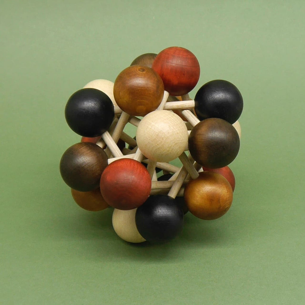Holzpuzzle in Kugelform, bestehend aus verschiedenfarbigen Holzkugeln, die durch kurze Holzstäbe verbunden sind, vor grünem Hintergrund.