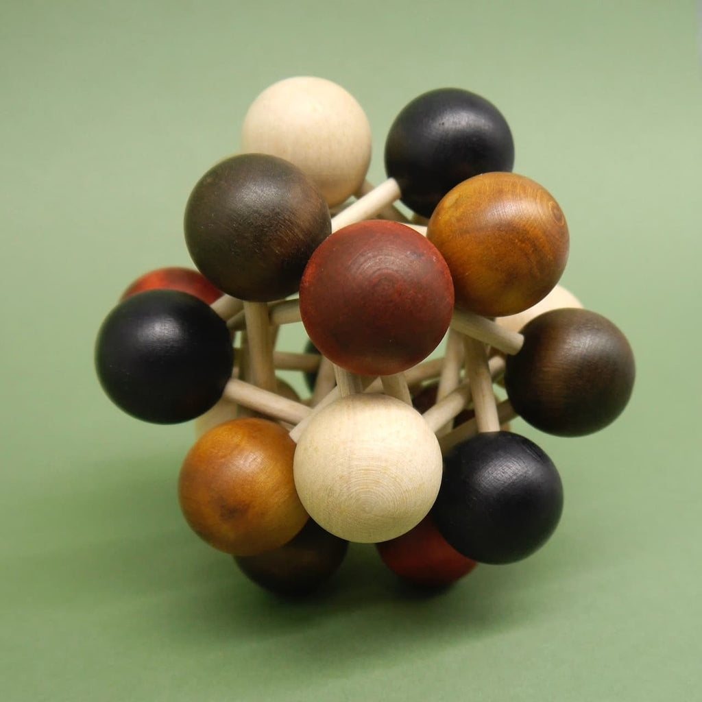 Nahaufnahme eines komplexen Holzpuzzles mit farbigen Holzkugeln, die durch Holzstäbchen zu einer geometrischen Struktur verbunden sind.