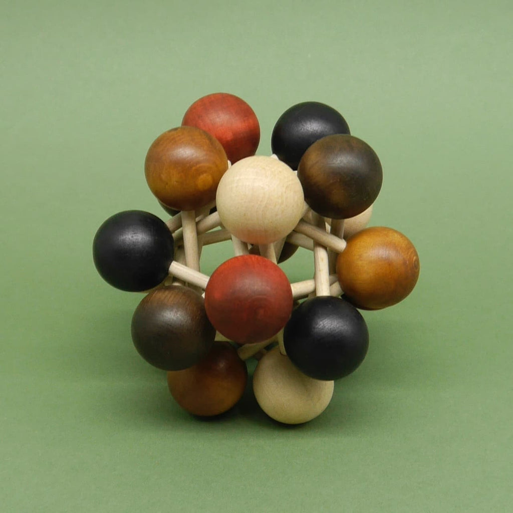 Holzpuzzle aus farbigen Kugeln, die über Holzstäbe miteinander verbunden sind, als Denkspiel arrangiert vor einfarbig grünem Hintergrund.