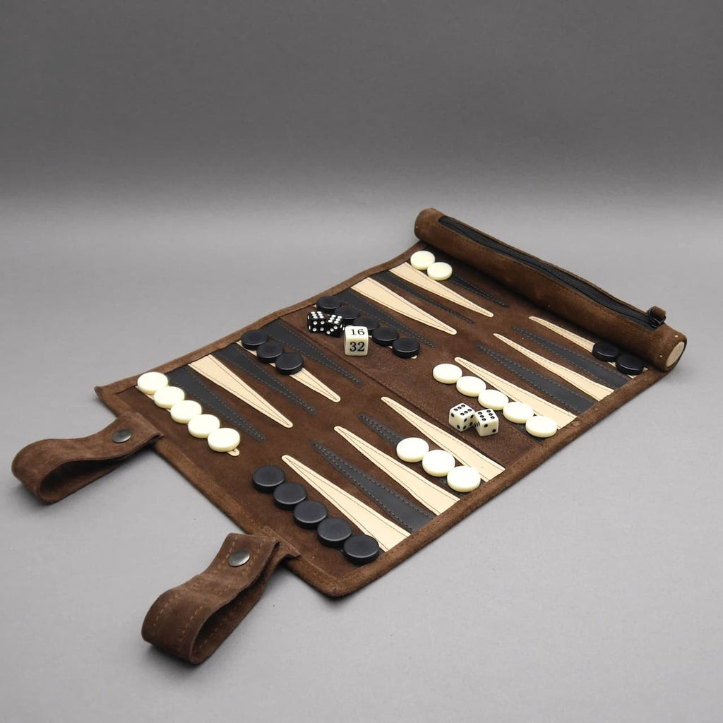 Offenes Backgammon aus braunem Leder mit weißen und schwarzen Steinen sowie Würfeln auf grauem Hintergrund.