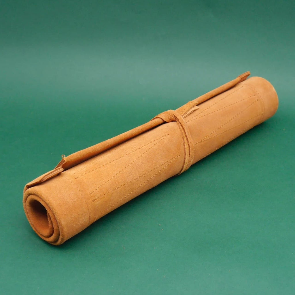 Gerolltes Backgammon-deluxe aus Wildleder; kompaktes Glücksspiel im Reiseformat auf grünem Hintergrund.