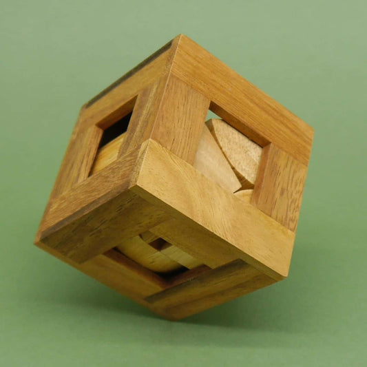 Denkspiel: Würfelförmiges Holz-Puzzle mit offenem Rahmen, in dem helle Holzsegmente verschachtelt sind.
