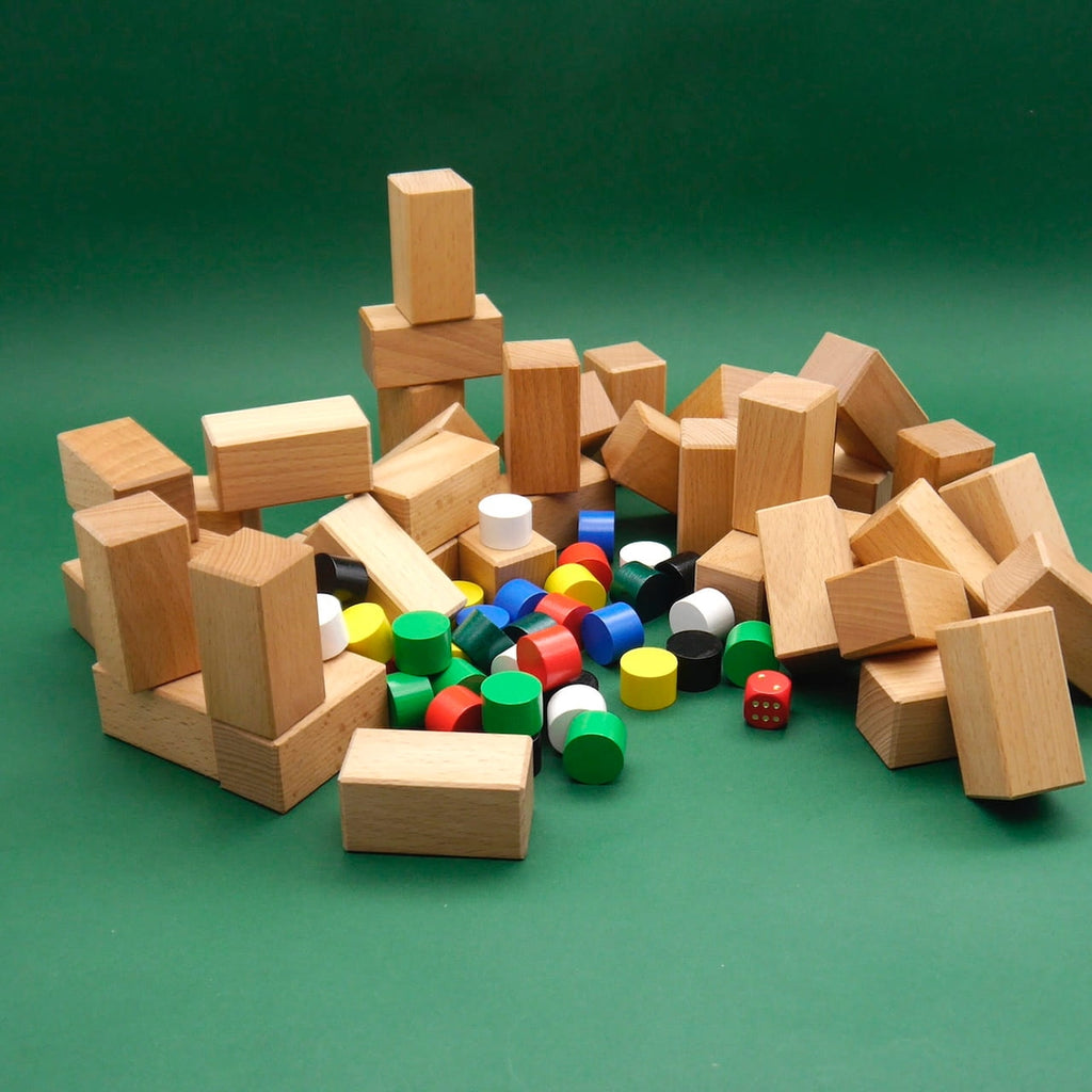Haufen Holzbausteine und bunte Spielsteine, vorbereitet für das Familienspiel Baubylon.