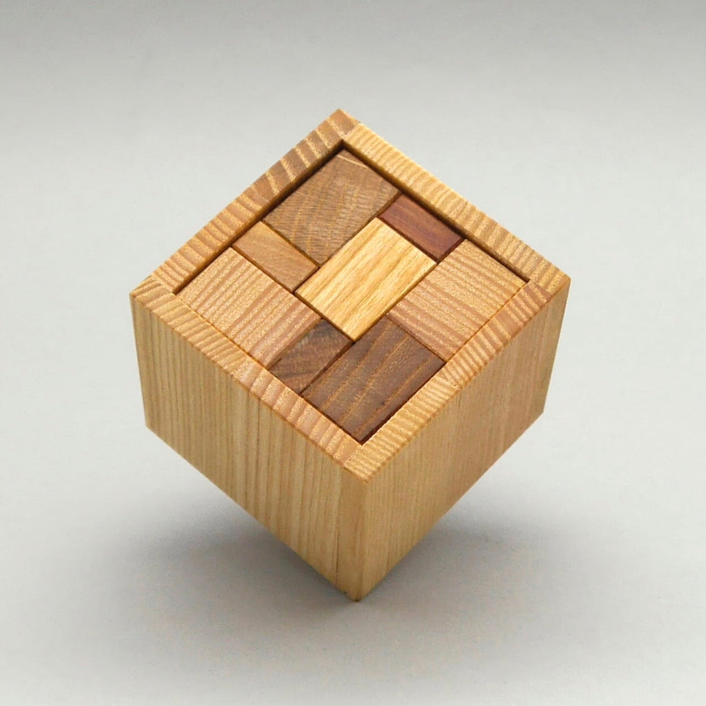 Bento Blox Holz-Geduldspiel: fertig zusammengesetzter Würfel mit passgenau eingelegten Holzstücken auf hellem Hintergrund.