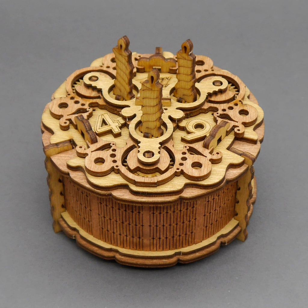 Holzbox in Form einer Geburtstagstorte mit drei Kerzen und Zahlen als dekoratives Geburtstagsgeschenk.