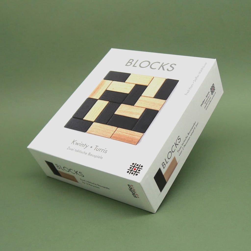 Verpackung des Holzspiels 'Blocks' mit schwarzen und naturfarbenen Bausteinen – ein pädagogisch wertvolles Kinderspiel