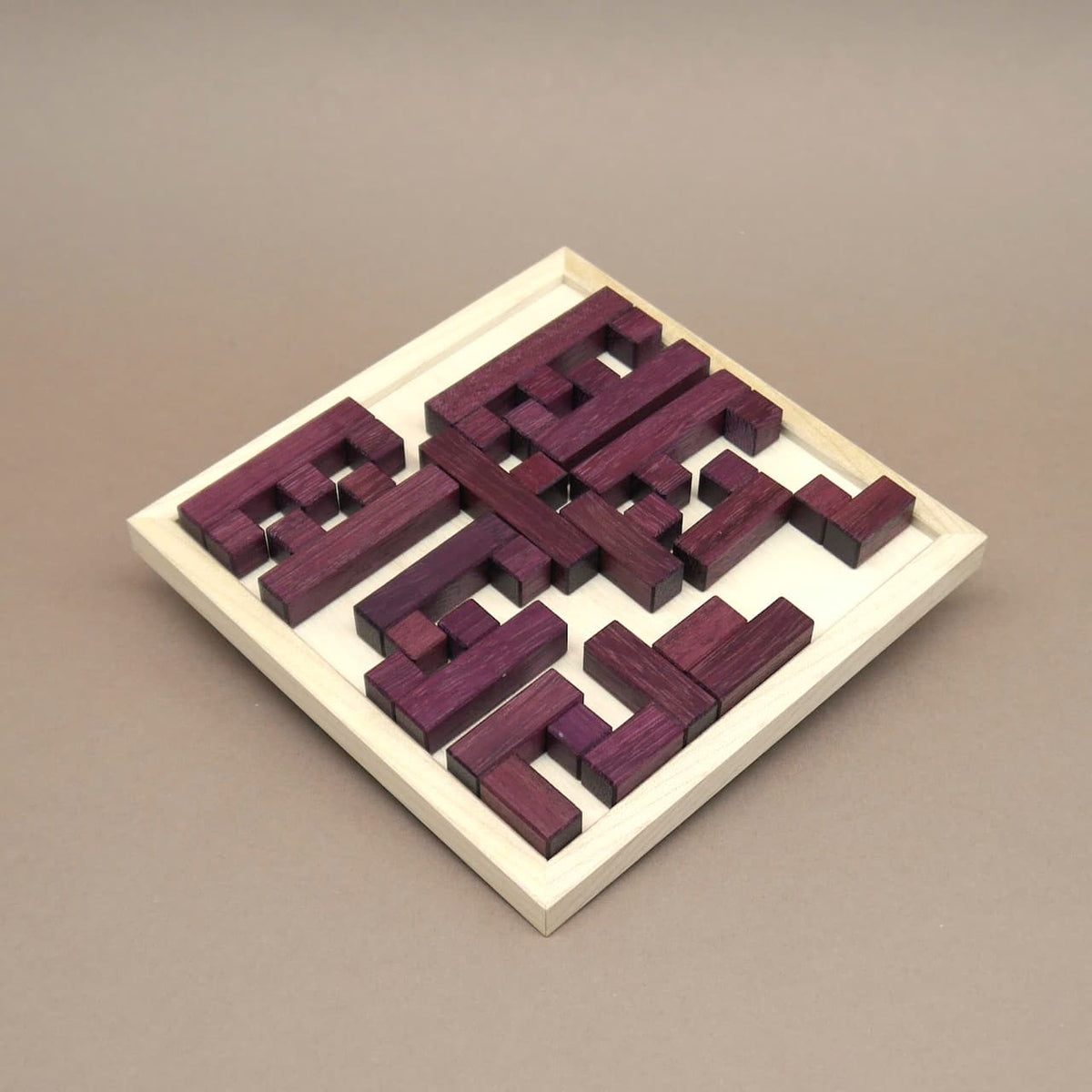 Vollständig zusammengesetztes Holz-Legepuzzle „Broken Frame and Window“ mit passgenau eingelegten lila Holzstücken.