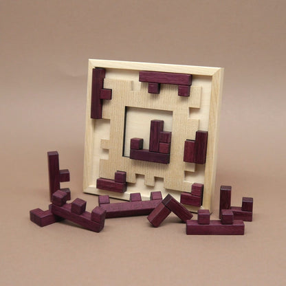 Holz-Packing-Puzzle „Broken Frame and Window“ mit lila Holzformen, teilweise eingesetzt in das quadratische Spielfeld.