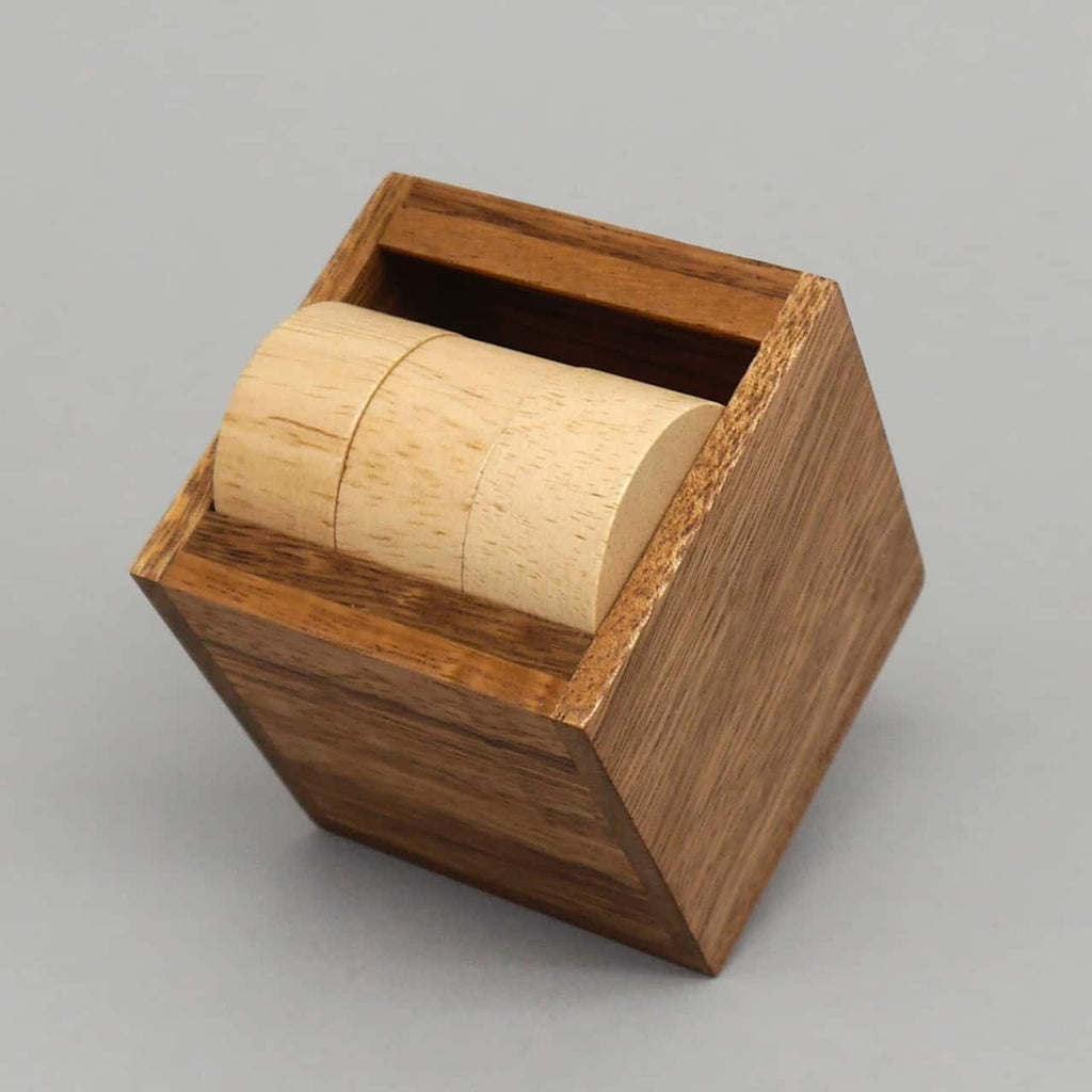 Teilweise gelöstes Woodenpuzzle von Rombol: Casino-Zylinder sitzen passgenau in einem eleganten Holzwürfel, kniffliges Rätselpuzzle.