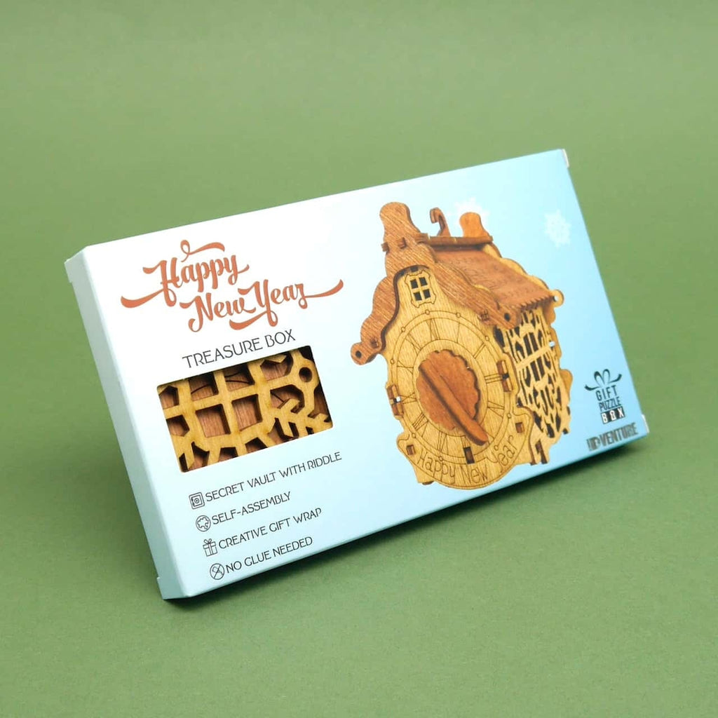 Verpackte Cluebox mit Neujahrsdesign; Blick auf Holzpuzzle-Teile durch Sichtfenster – ideale Schatzkiste zum Verschenken.