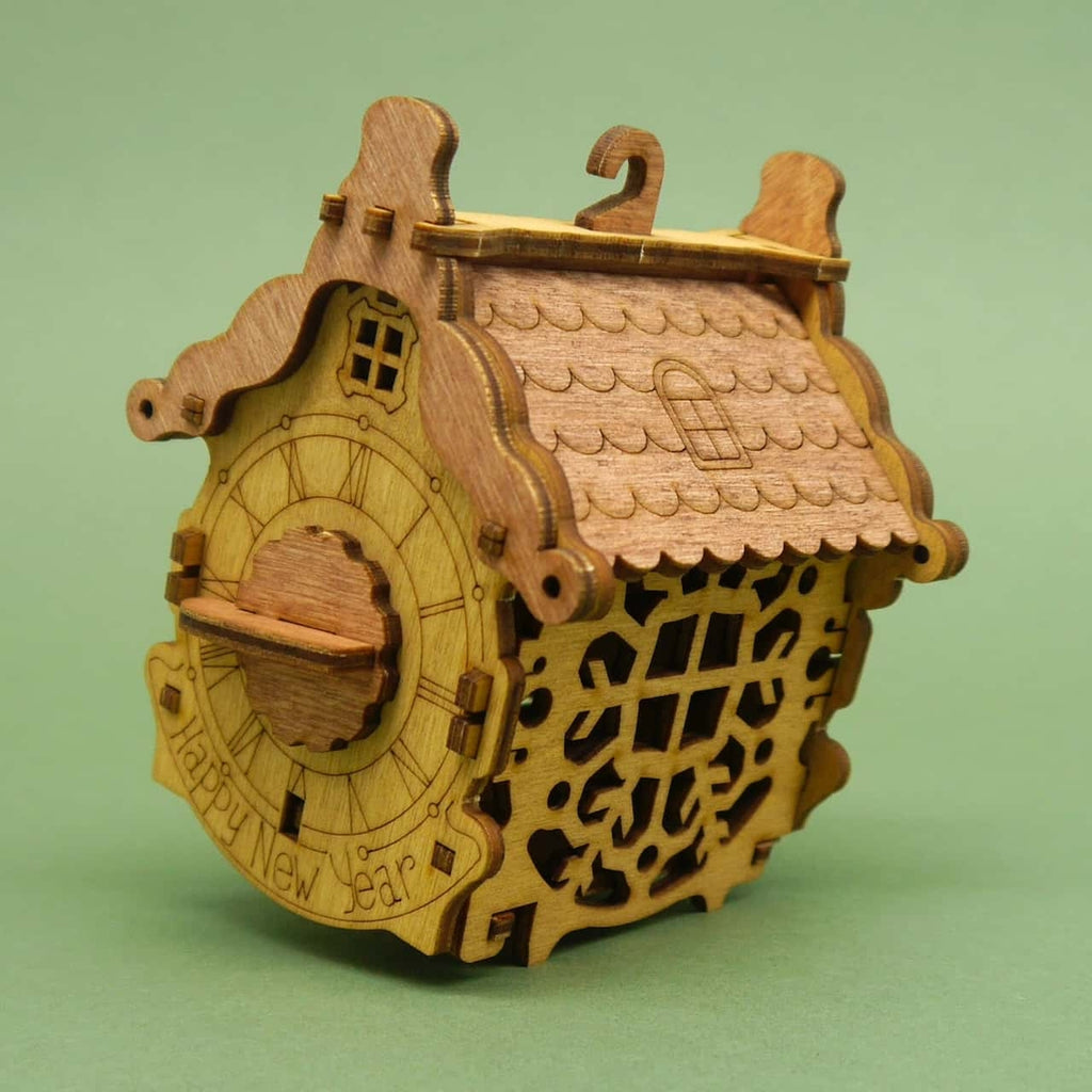 Detailaufnahme der hölzernen Cluebox in Häuschenform mit Gravuren und Drehmechanik – raffiniertes Knobelspiel mit Geheimfach.