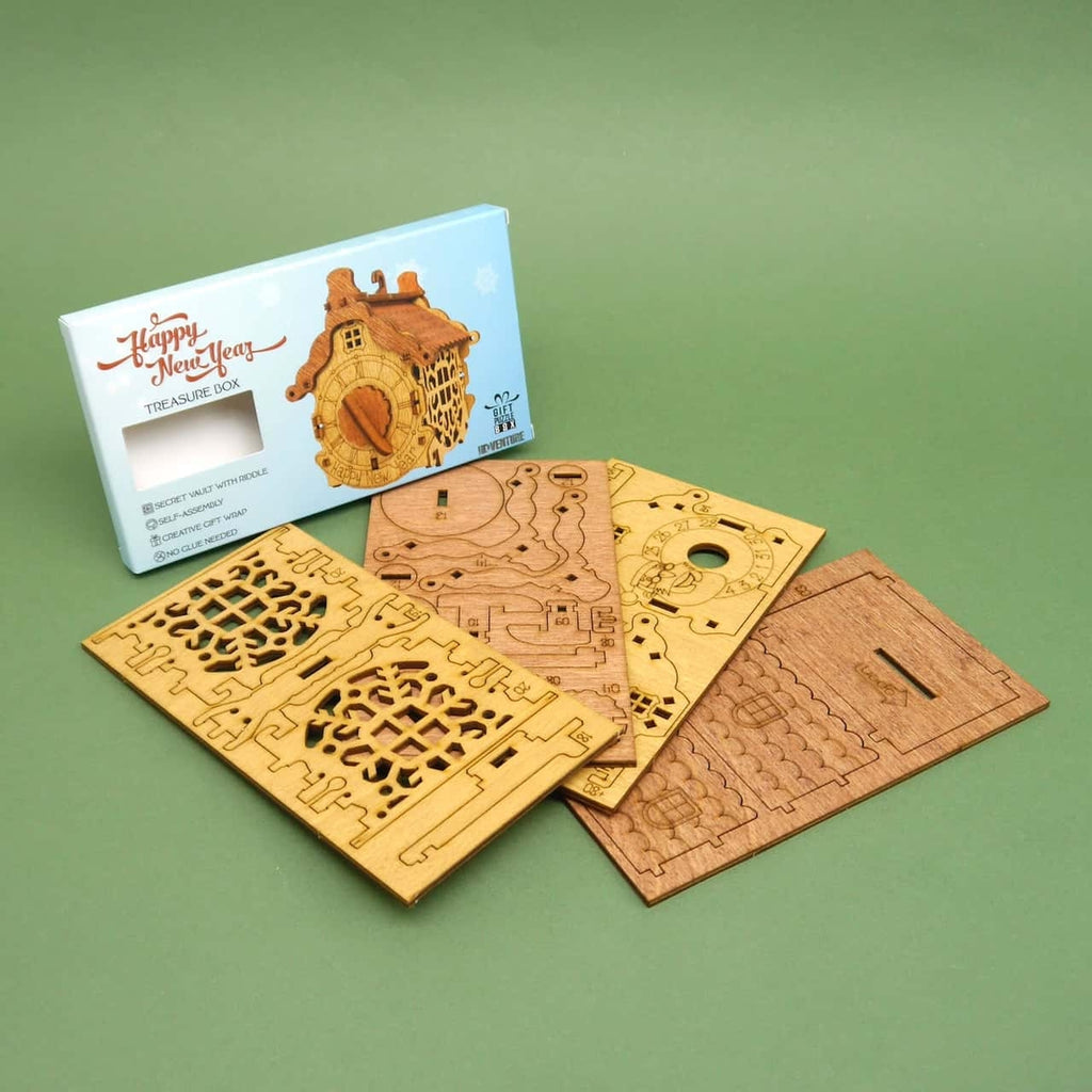 Ausgelegte Stanzplatten des DIY-Puzzles neben Produktverpackung; alle Teile vorbereitet zum Aufbau der Holzbox.